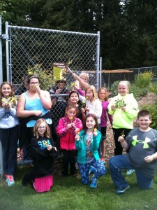 Students show off yellow kale flowers favored by many pollinator species, in front of their school garden